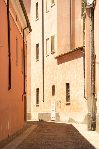 A vertical shot of a pathway in the middle of buildings at daytime