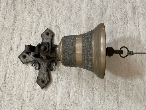 A vintage medieval bell hanging on a wall