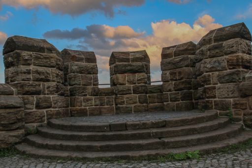 An old wall with blue sky and clouds in the background