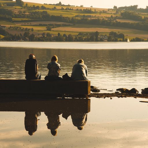A closeup shot of three men sitting at the lake in Sempach in Switzerland on a bright sunny day