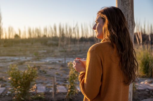 A pretty Hispanic woman drinking coffee and watching the sunset