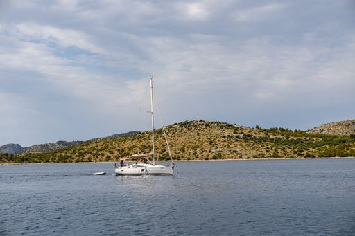 A closeup shot of a small boat sailing in the sea under a cloudy sky in Dlugi Otok, Croatia