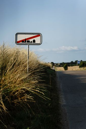 The sign by the road shoring the end of residential area