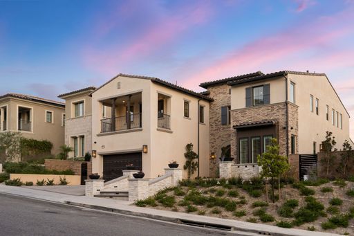 Modern suburban homes with landscaped front yards and a beautiful sky at dusk.