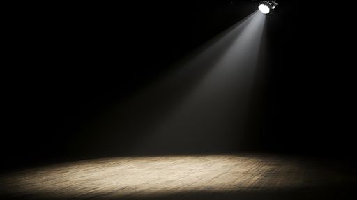 A spotlight illuminating an empty wooden stage in a dark theater, creating a dramatic atmosphere.