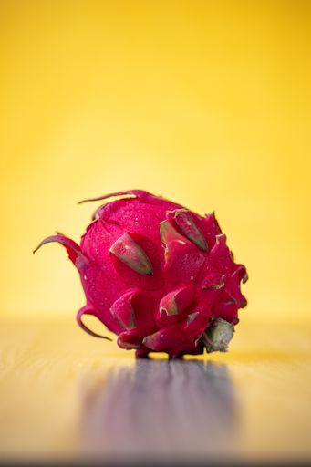 A closeup shot of a fresh Dragon fruit on a yellow background