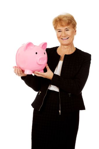A senior elegant Caucasian woman holding a piggy bank isolated on a white background