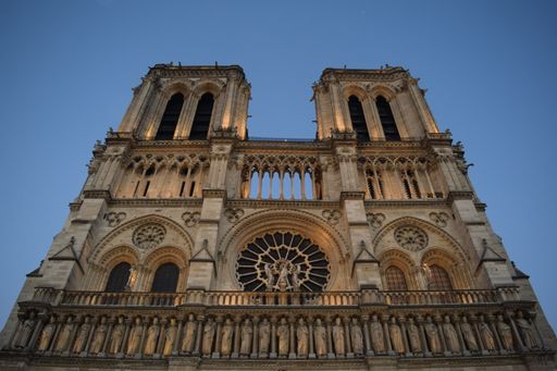 A low angle shot of Notre-Dame cathedral in Paris, France under a blue sky