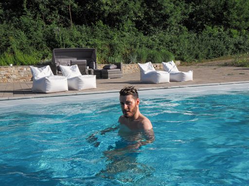 An Italian Caucasian man in the pool on a sunny day