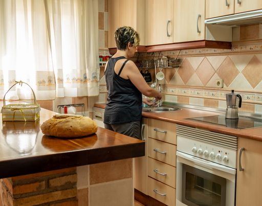 A closeup shot of a Caucasian female in her home furnished kitchen
