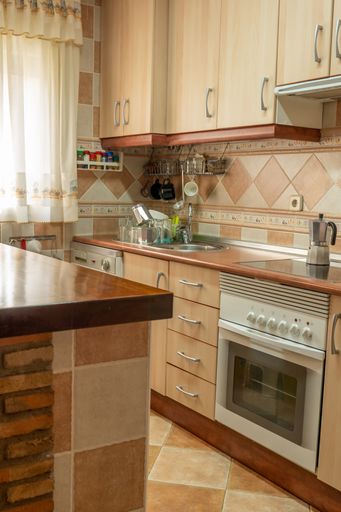 A vertical shot of a furnished home kitchen interior on a bright day