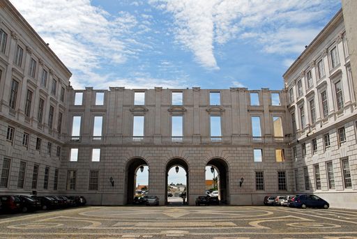 The Ajuda National Palace courtyard and parking area against a cloudy sky in Lisbon, Portugal