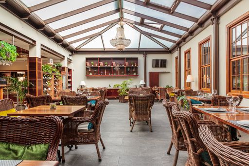 A cozy restaurant atmosphere, comfortable armchairs, and wooden tables with a crockery-good idea for ad