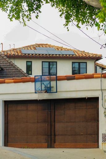 A vertical shot of a basketball hoop on the wall of a closed garage