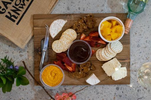 A top view of assorted snacks on a wooden tray