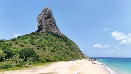 A stunning view of Morro do Pico on Fernando de Noronha island with a pristine beach and clear blue sky.