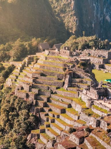 Aerial view of Machu Picchu's iconic terraced landscape and ancient stone structures in Peru.