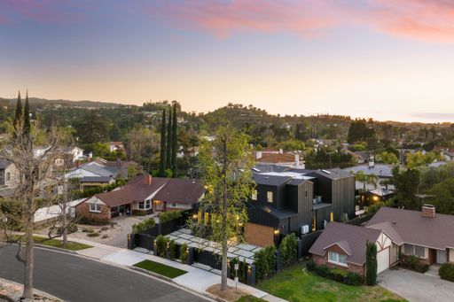 Aerial view of suburban neighborhood with modern and traditional houses at sunset.