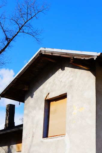 The facade of an old building with chipped cement