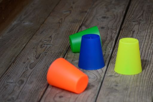 A closeup shot of colorful plastic cups on a wooden surface