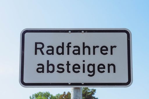 A sign in german "Radfahrer absteigen"- means cyclists should dismount and walk