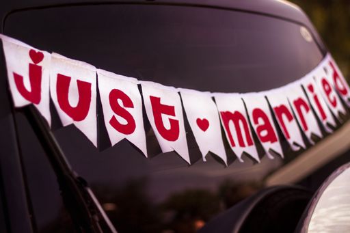 A closeup shot of a red text "Just Married" written on white pieces on a car glass