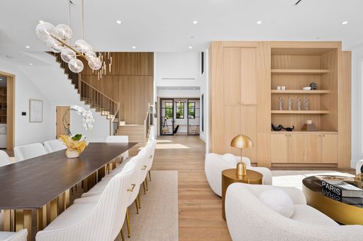 A modern and spacious living room and dining area with elegant furniture and wooden accents.