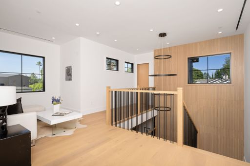 A modern and bright interior space with wooden flooring, large windows, and contemporary decor.