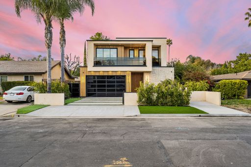 Modern two-story house with a sleek design, large windows, and a well-maintained front yard under a pink and purple sunset sky.