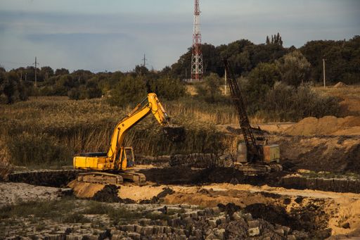 A closeup shot of an ongoing construction  with tracks and a bulldozer on an  abandoned land