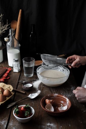 A vertical shot of a woman baking on a wooden table in the kitchen