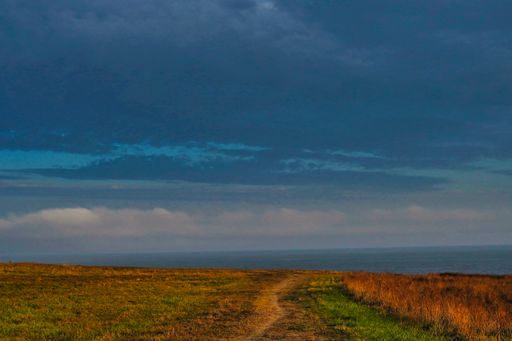 An empty field under a blue cloudy sky in La Coruna in Galicia, Spain
