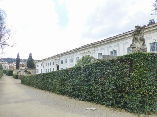 A large white building surrounded by green plants in Florence, Italy