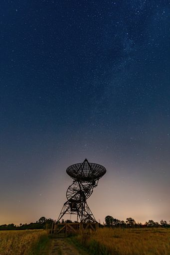An eerie scenery of a radio telescope on a starry night