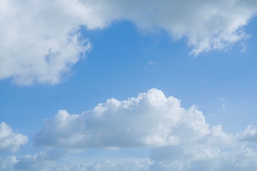 A bright blue sky filled with fluffy white clouds on a clear day.