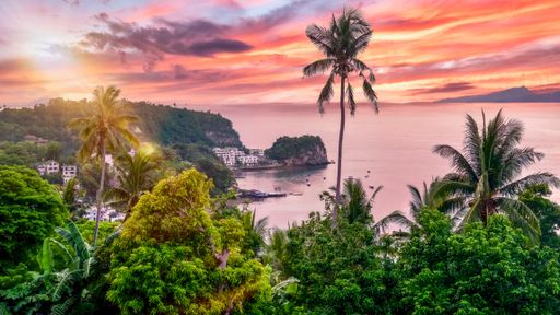 An idyllic tropical island sunset over the dive resort of Sabang Beach in Puerto Galera, Oriental Mindoro, Philippines.