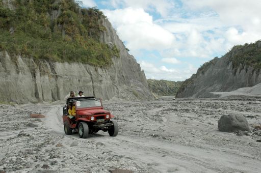 A closeup shot of a jeep in rough volcanic ash landscape at Pinatubo volcano site in Philippines