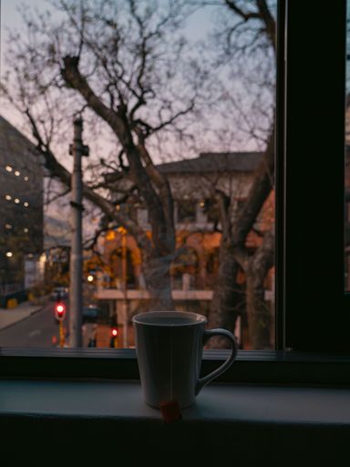 A mug placed on a window sill, capturing the essence of a winter morning, with light filtering in from outside