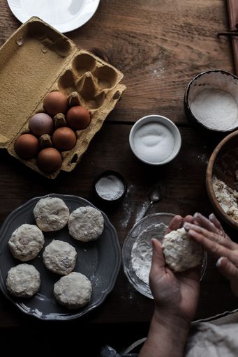 A vertical shot of hands making delicious pastry out of dough