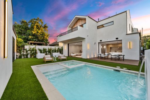 Modern luxury home with pool and outdoor seating at sunset, showcasing elegant architecture and vibrant sky.