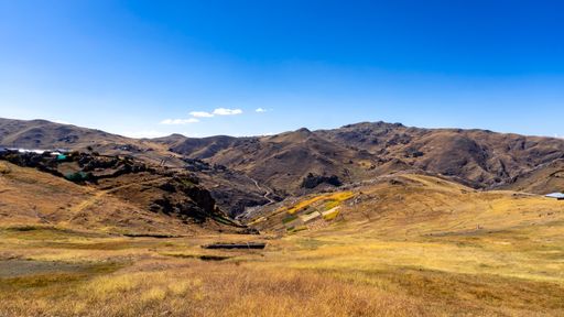 A panoramic shot of a beautiful landscape of the mountains in Peru under the blue sky