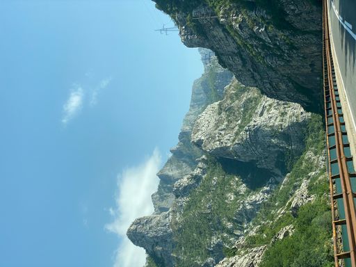 A vertical shot of the rocky hills and a river from a motorway