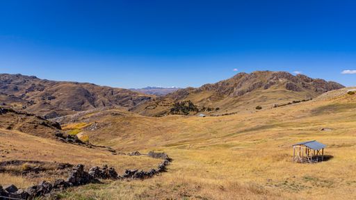 A panoramic shot of a beautiful landscape of the mountains in Peru under the blue sky