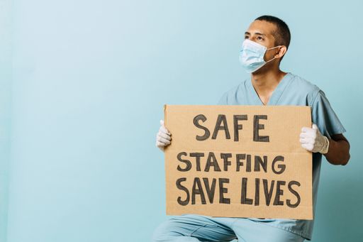 A young male doctor holding a banner about the covid vaccine.