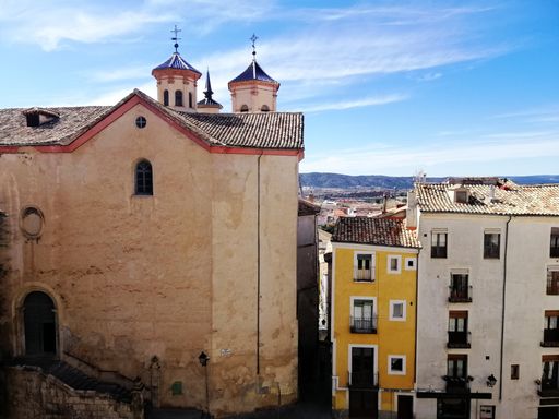 A beautiful shot of colorful buildings and a church in Cuenca Spain under a blue sky