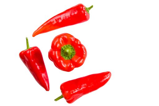 Red bell peppers and chili peppers arranged on a white background, showcasing their vibrant color and fresh texture.