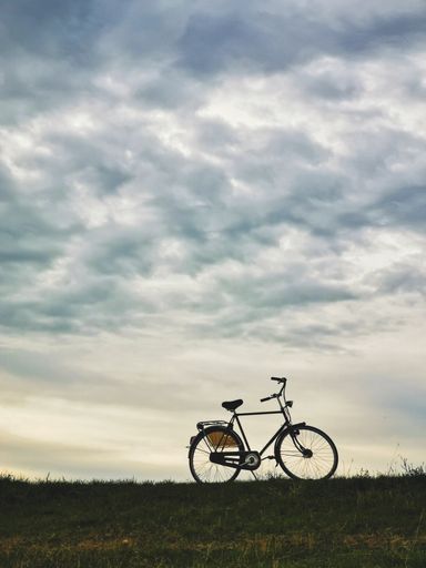 Citybike parked on a dam with a cloudy sky in the background.
