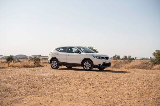 An automobile on the rural field with a clear sky background