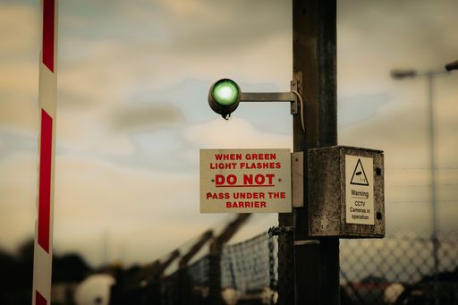 A warning sign at a railway crossing with safety instructions