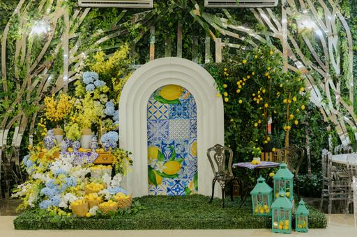 Vibrant indoor garden setup with lemons, flowers, and a decorative archway, featuring lush greenery and colorful decor.